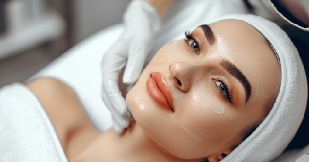 High-angle close-up of a woman getting a vampire facial with cream, looking relaxed as a gloved hand touches her cheek in Brooklyn.